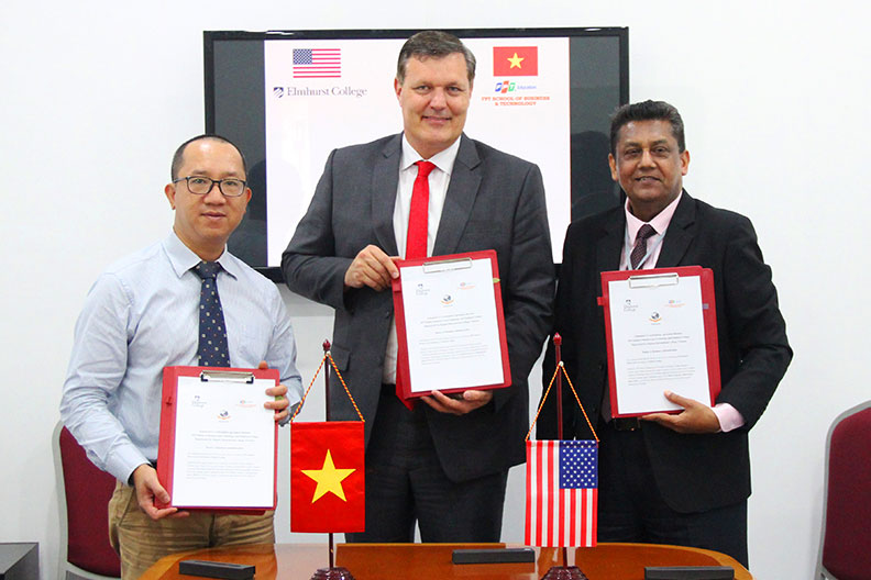 Elmhurst College President Troy D. VanAken, center, holds a signed agreement with officials from Vietnam's FPT School of Business and Technology.