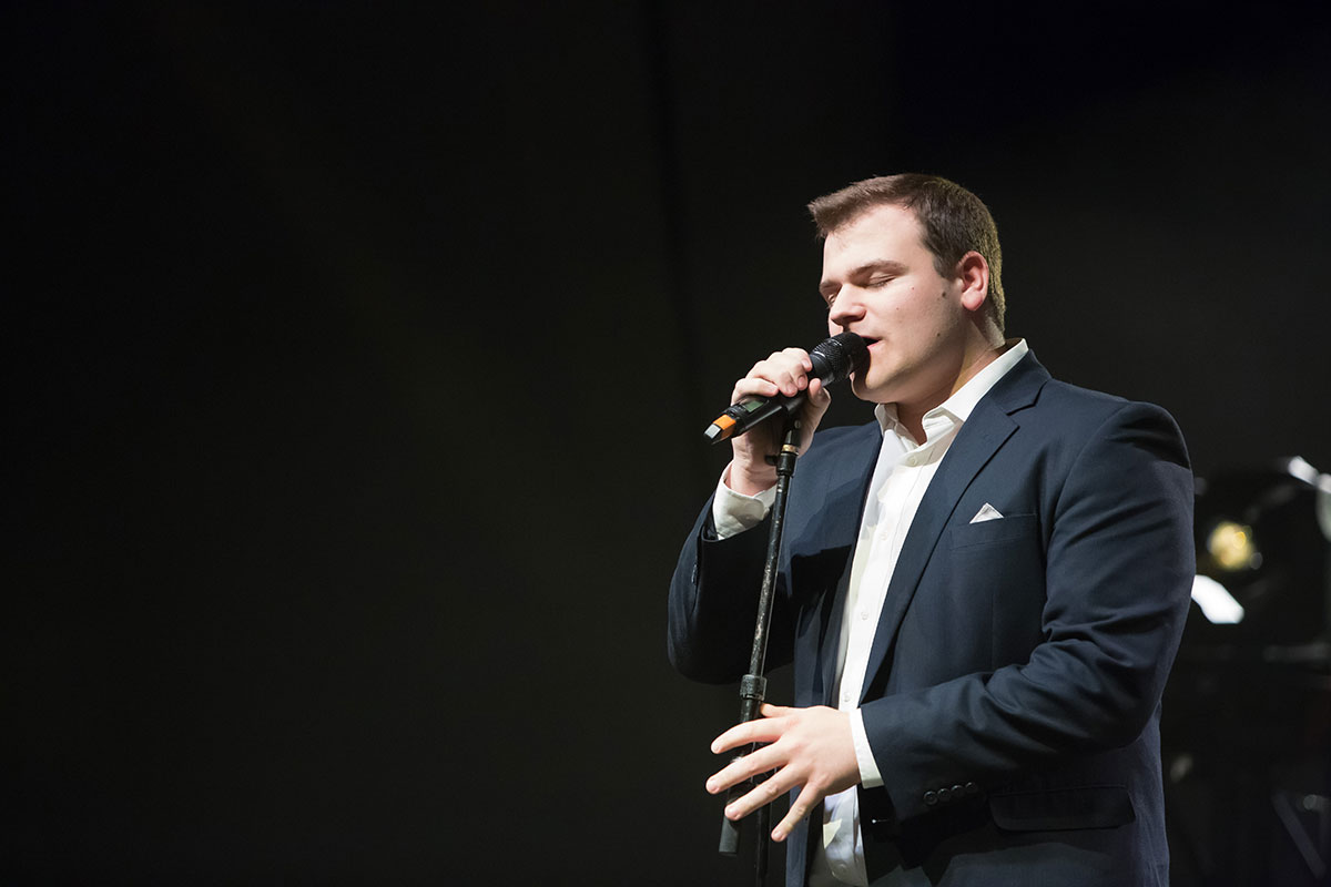 Matt Cloud cradles the microphone and sings during Elmhurst College's annual talent show, EC on the Rise, in 2018.