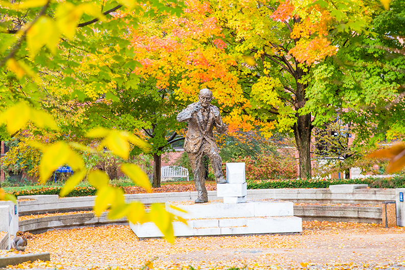 Reinhold Niebuhr statue surrounded by fall colors in the Kranz Forum on the campus of Elmhurst University in Elmhurst, IL.