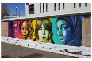 "Color Isn't Race," a public mural in Denver, Colorado, featuring four diverse people shaded in different colors by artist and Elmhurst College faculty member Rafael Blanco.
