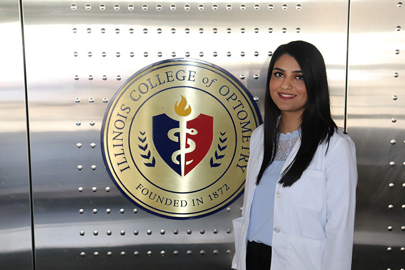 Photo of Elmhurst College in academic centers student Ruba Ahmad getting her white coat at Illinois College of Optometry.