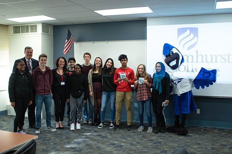 A group of Willowbrook High School students poses with Elmhurst College president Troy VanAken and mascot Victor E. Bluejay at a special welcome event.