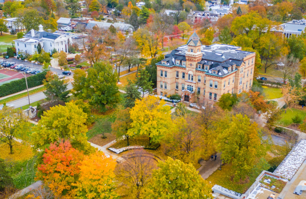 An aerial photograph of the Elmhurst College includes an overhead view of Old Main and other campus buildings in the fall.
