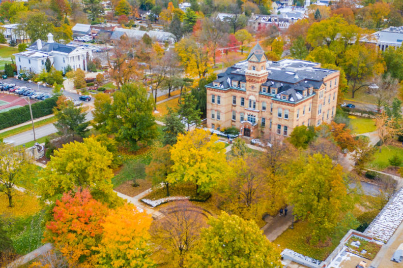 An aerial photograph of the Elmhurst College includes an overhead view of Old Main and other campus buildings in the fall.