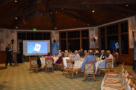 Elmhurst University alumni gather in front of a video screen for the President's Road Trip event in Naples, FL.