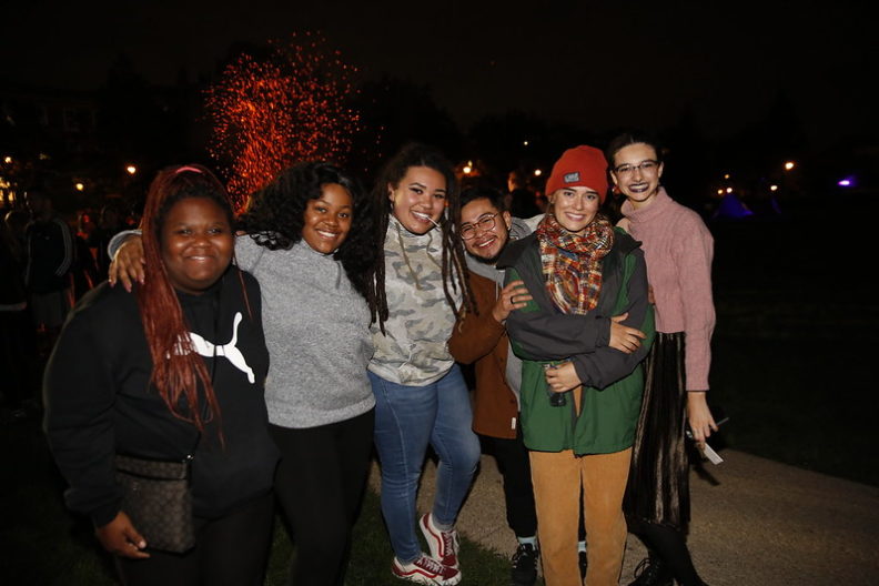 A group of Elmhurst University students pose for a photo at night.