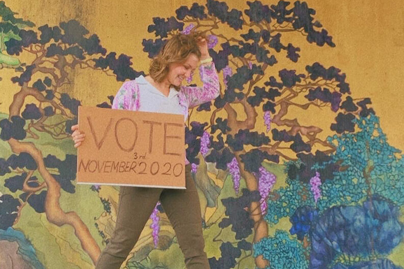 Elmhurst University student Hannah Bacon holds a sign that says "Vote in November 2020."