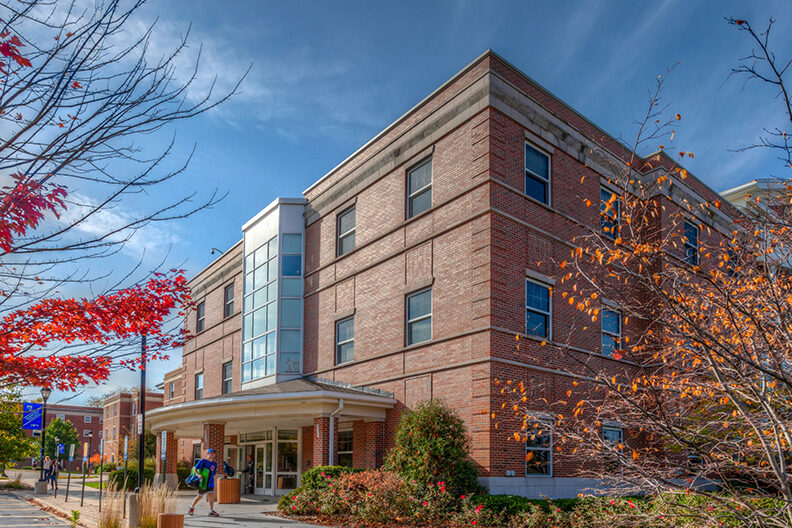 An exterior photo of Circle Hall with a student walking outside.