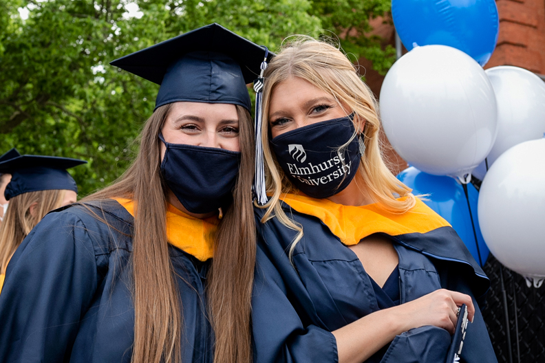 Two graduate students smile before their Commencement ceremony on Friday, May 21, 2021