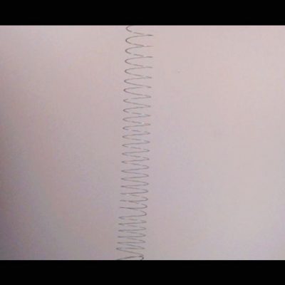 A photo of a silver slinky extended vertically.