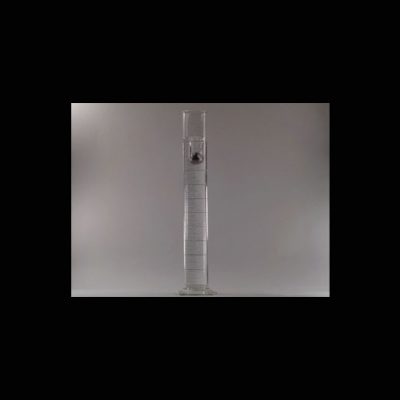A photo of a hollow clear tube with a ball being dropped down it.