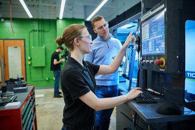 A female Elmhurst University student uses a Tormach prototyping machine in the Elmhurst University Maker Space.