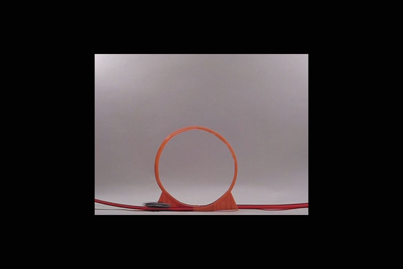A photo of a looping orange track for a matchbox car.