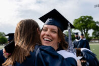 Two Elmhurst University graduate students hug following the 2021 Commencement ceremony.