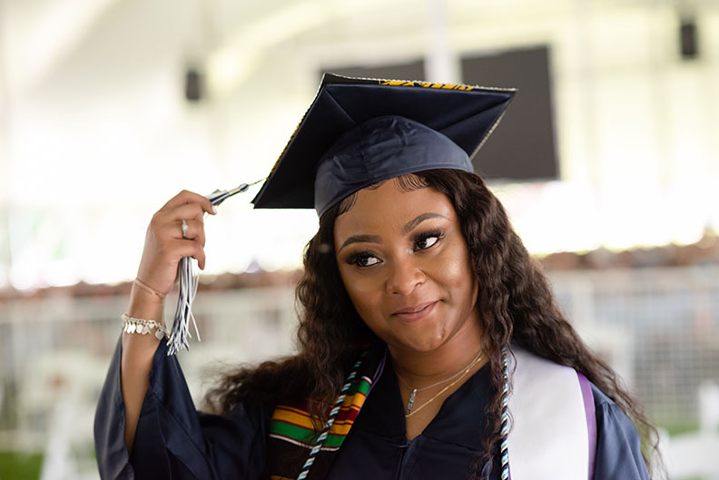 A female Elmhurst University graduate holds the tassel on her cap during the 2021 Commencement ceremony.