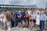 A group of Elmhurst University alumni pose for a group photo at a baseball game in Atlanta as part of the 2021 President's Road Trip.