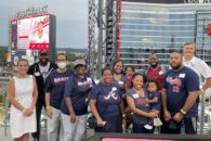 A group of Elmhurst University alumni pose for a group photo at a baseball game in Atlanta as part of the 2021 President's Road Trip.
