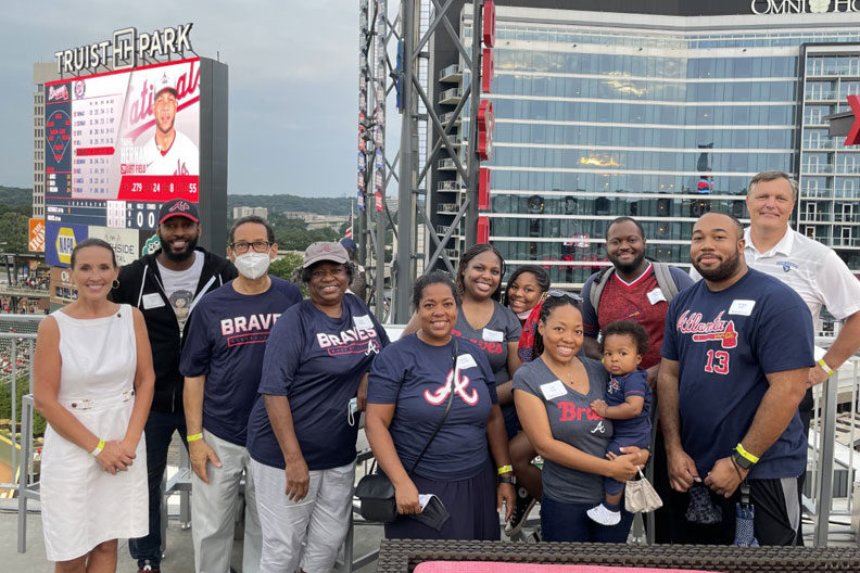 A group of Elmhurst University alumni pose for a group photo at a baseball game in Atlanta as part of the 2021 President's Road Trip.