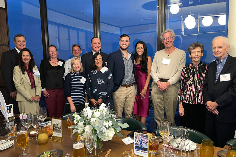 Elmhurst University alumni pose for a group photo behind a dinner table during the 2021 President's Road Trip event in Detroit, MI.