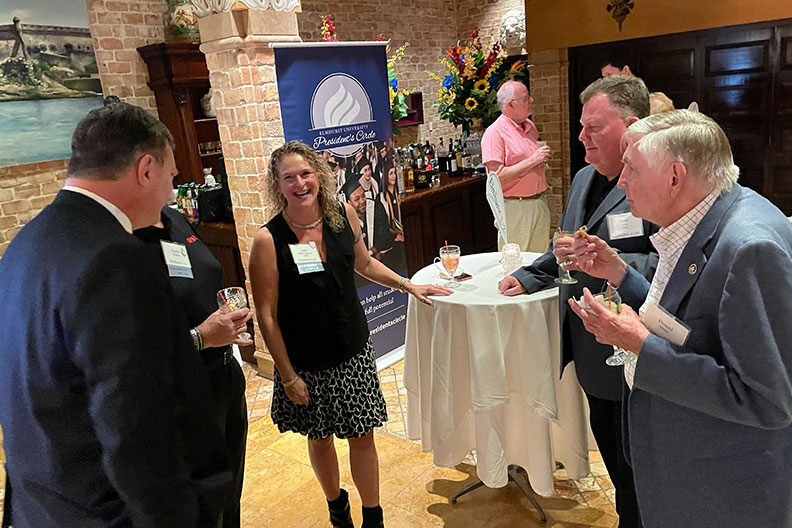 Guests speaking to President Troy VanAken at the President's Road Trip Tampa event.