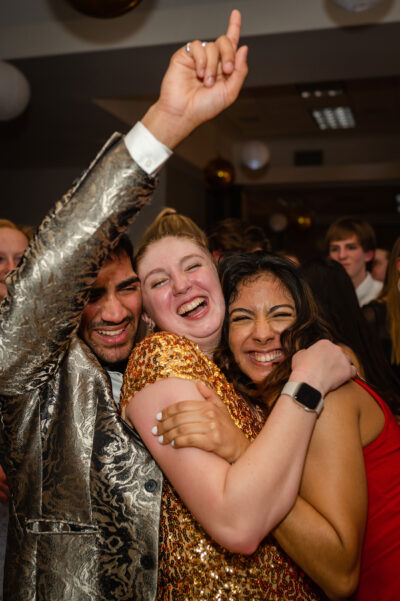 A group of Elmhurst University students hug and cheer during the 2022 Presidents' Ball event in Elmhurst, IL.