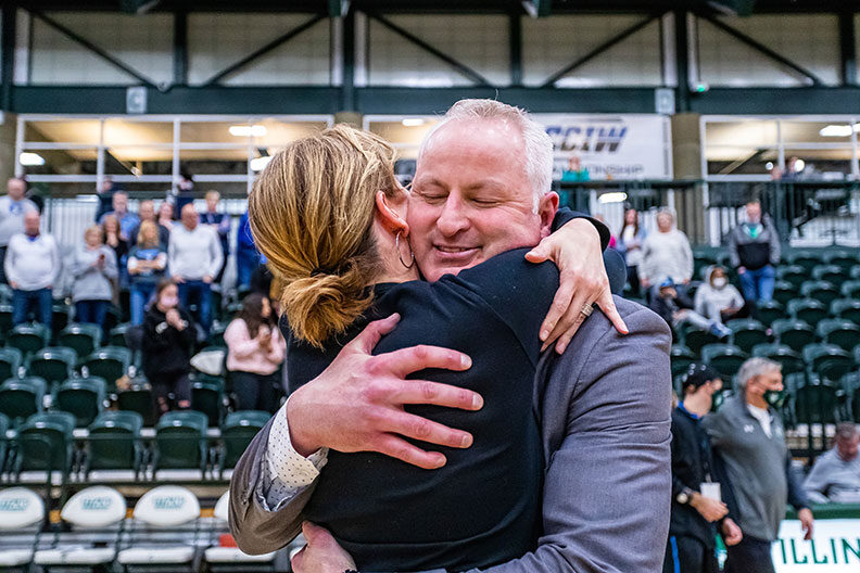 Elmhurst University men's basketball coach John Baines and his wife hug in celebration of Elmhurst's CCIW conference championship victory in February of 2022.