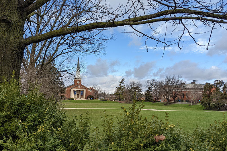 The Hammerschmidt Memorial Chapel, framed by a tree branch, on the campus of Elmhurst University.