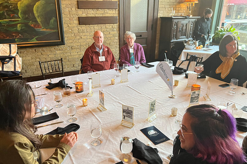 A group of Elmhurst University alumni sit at a dinner table during the 2022 President's Road Trip event in Minneapolis, MN.