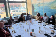 A group of Elmhurst University alumni sit at a dinner table during the 2022 President's Road Trip event in Minneapolis, MN.
