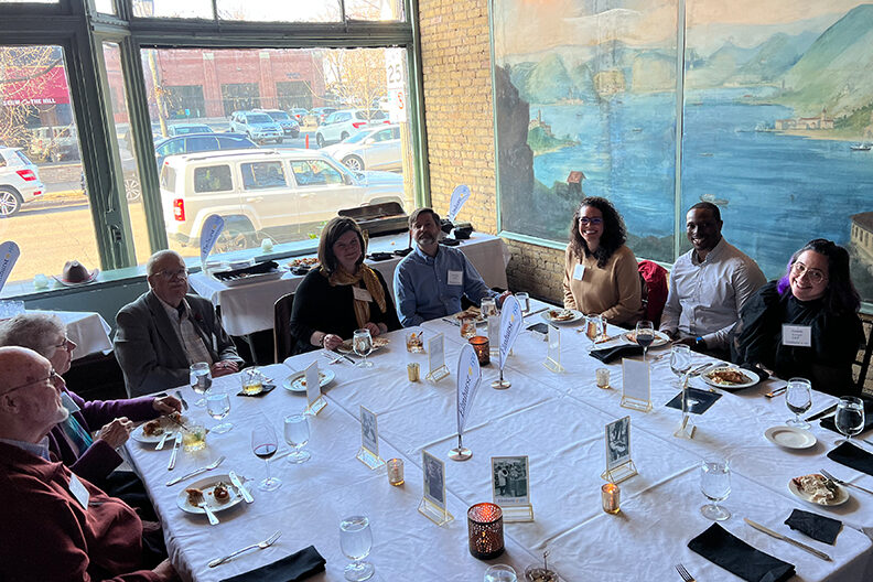 A group of Elmhurst University alumni sit at a dinner table during the 2022 President's Road Trip event in Minneapolis, MN.