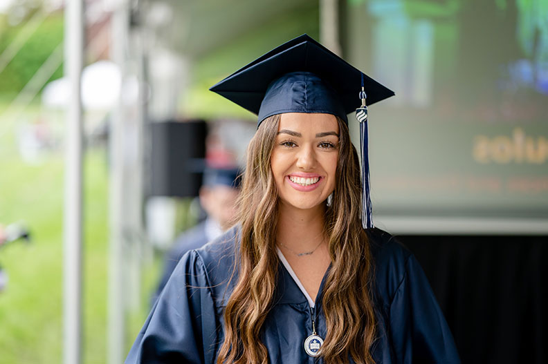 An Elmhurst University student smiles during her graduation ceremony during the University's 2022 Commencement.