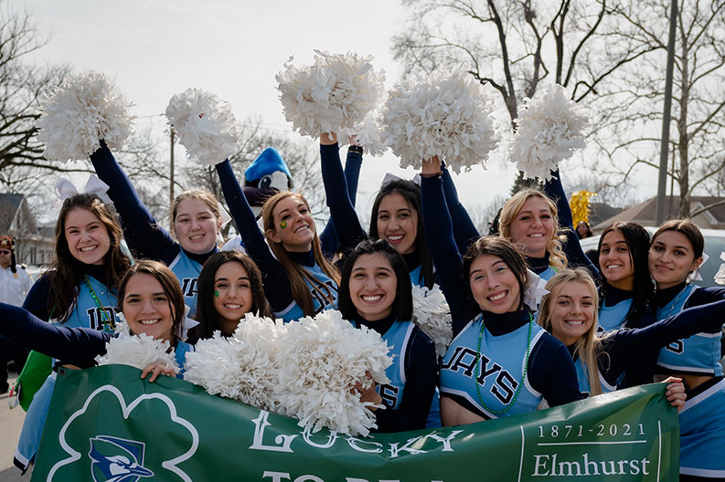 The Elmhurst Bluejays cheerleading squad raises its pompoms during the 2022 City of Elmhurst St. Patrick's Day Parade.