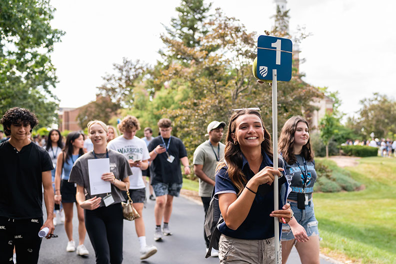 A group of Elmhurst University students walk together across campus during the first day of new student orientation in August of 2022.