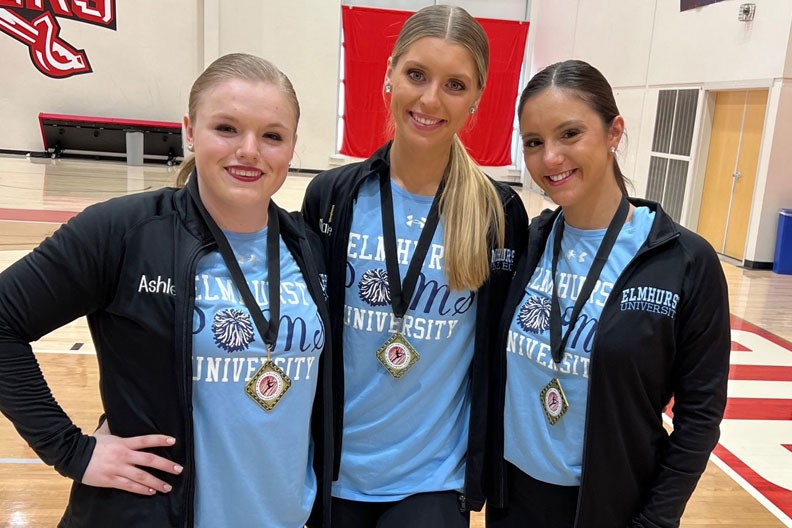 Three members of the Elmhurst University Poms team wearing medals they won in competition.