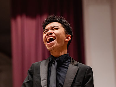 A male student dressed in black sings during Elmhurst University's annual Festival of Lessons and Carols concert.