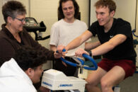 Kinesiology students test a piece of exercise equipment in a classroom at Elmhurst University.