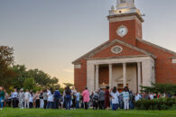 Elmhurst University's Hammerschmidt Memorial Chapel in the background, with nursing students and their families gathered outside the building.