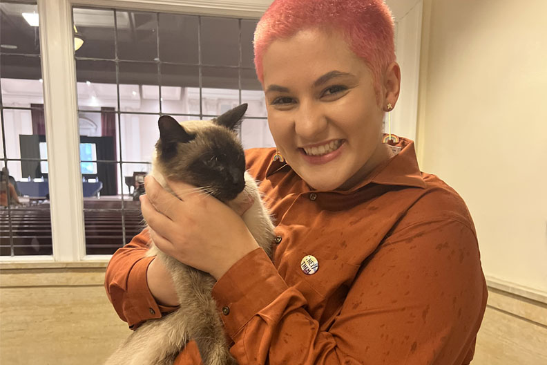 Emerson Azcoitia, of Elmhurst University, holding a cat.
