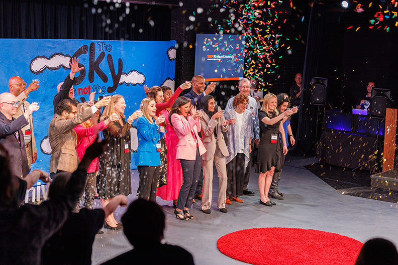 Group of people celebrating TEDx at Elmhurst University with confetti
