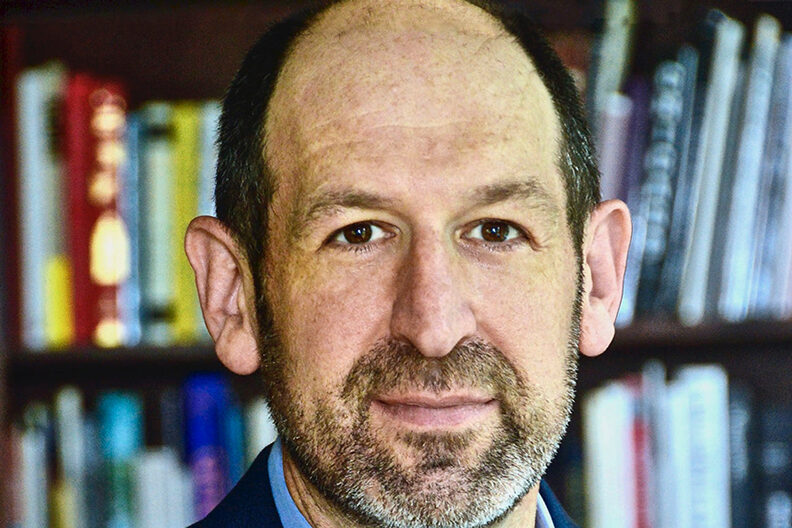 Man standing in front of a bookshelf