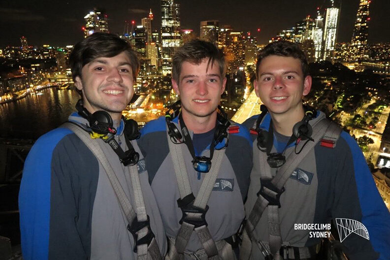 Three men are at a lookout point in Sydney, Australia