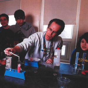 Chemistry teacher Glen Lid performing a demonstration for students watching behind him.