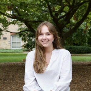 Headshot of Milena Trojan in front of trees and grass, outdoors