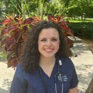 Headshot of Nicolleta Boik in front of flowers, outdoors