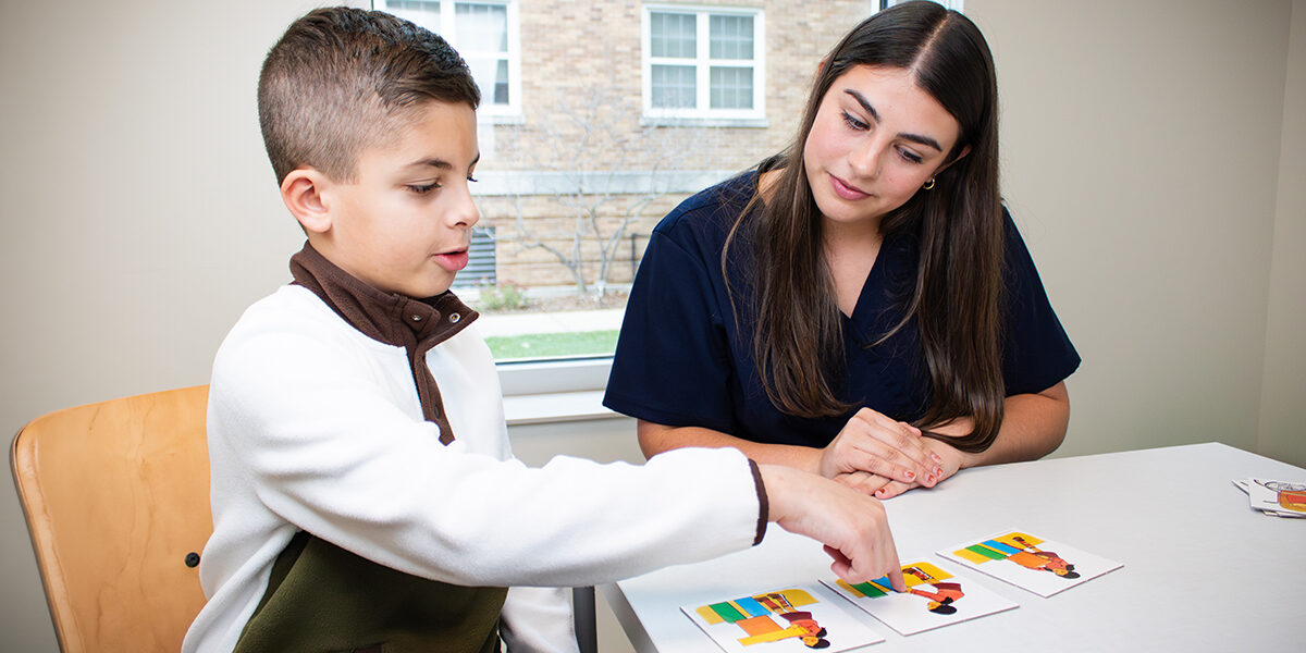 Young student seated with teacher