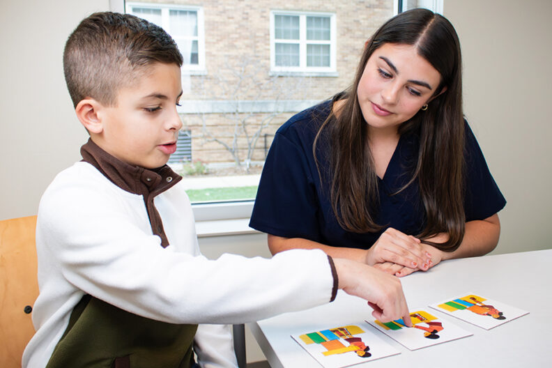 Young student seated with teacher