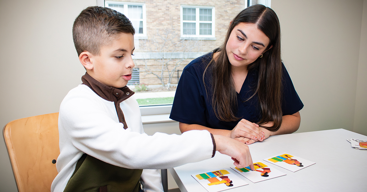Young student seated with teacher