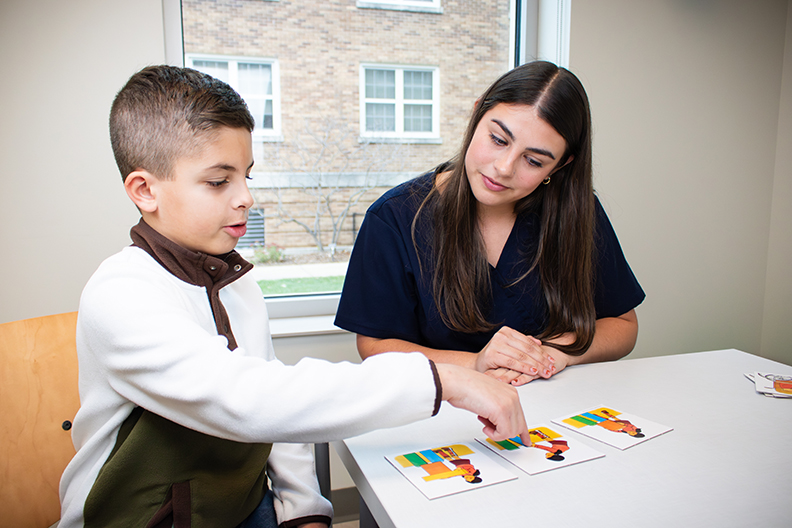 Young student seated with teacher